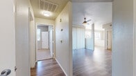 This single-floor residence offers a thoughtfully designed layout that balances comfort and functionality throughout. The entryway opens into a bright, open-concept living area finished with rich wood-look plank flooring that extends through the main spaces. The living room is anchored by a ceiling fan and large sliding glass doors framed by vertical blinds, inviting abundant natural light and providing direct access to an outdoor patio area with views of surrounding greenery.

The kitchen is outfitted with white shaker-style cabinetry, light countertops, a grey subway tile backsplash, and a full suite of stainless steel appliances, including a range, microwave, and dishwasher. The clean, neutral palette gives the kitchen a fresh and modern feel.

The bedrooms feature plush wall-to-wall carpeting and are served by ceiling fans. Several rooms include walk-in or reach-in closets with built-in shelving, while large windows with horizontal blinds allow for generous natural light and outdoor views. One bedroom connects directly to a bathroom, offering added privacy.

The bathrooms are finished with wood-look flooring, white vanity cabinetry, and full soaking tub and shower combinations with white tile surrounds. The overall ambiance of the space is clean, neutral, and move-in ready.