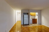 Located at 3435 Holmead Pl NW in Washington, DC, this efficiently designed studio unit makes thoughtful use of its single-floor layout. The space is anchored by warm, parquet hardwood flooring that runs throughout the main living area, lending a classic character to the interior.

Upon entering, a hallway leads into the combined living, dining, and kitchen area — the heart of the unit. The open living space is bright and clean, featuring neutral gray walls and a window fitted with blinds and a window AC unit, allowing for natural light and ventilation. A radiator beneath the window provides traditional heating.

The kitchen is tucked into a defined nook, outfitted with warm wood cabinetry, a gas range, refrigerator, and a sink with countertop space — providing all the essentials in a compact, practical footprint. Tile flooring in the kitchen area transitions cleanly from the hardwood of the main living space.

The bathroom is finished with classic white subway tile wainscoting, a wood-vanity with a mirror, a toilet, and a bathtub/shower combination. Overhead vanity lighting provides good illumination. A closet rounds out the unit, offering dedicated storage. The overall ambiance is straightforward and functional, well-suited to urban living in the Columbia Heights neighborhood of Washington, DC.