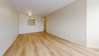 Located at 171 Lees Ave in Ottawa's centrally situated Glebe-area neighbourhood, this three-bedroom, two-bathroom unit offers a practical and well-organized single-floor layout. The open living room is a standout feature, boasting expansive wraparound windows that flood the space with natural light and provide sweeping views of the surrounding Ottawa cityscape. Light wood laminate flooring runs throughout the main living areas and bedrooms, lending a clean, cohesive aesthetic.

The kitchen is efficiently designed with white cabinetry, light countertops, tile flooring, a built-in dishwasher, and a full suite of white appliances including a refrigerator, electric stove, and range hood — all set beneath a bright grid-panel ceiling light. The kitchen connects seamlessly to the rest of the unit via a hallway corridor.

Three bedrooms offer comfortable accommodations, each featuring light wood flooring, neutral warm-toned walls, and individual windows that bring in natural light. The spacious primary bedroom is particularly notable for its generous proportions.

The two bathrooms are finished in clean white tones — one features a tiled walk-in shower stall, while the other includes a bathtub and a vanity with light countertop surfaces. Two hallways provide smooth circulation throughout the unit, and a dedicated closet adds practical storage.