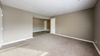 Located at 2100 N 57th St in Kansas City, KS, this four-bedroom, one-bathroom unit is thoughtfully arranged on a single floor, making for easy navigation throughout the space. Neutral taupe walls and crisp white trim create a consistent, clean aesthetic from room to room.

The four bedrooms are carpeted in a warm beige tone, providing a comfortable feel underfoot. Each room features white baseboards, standard closet access, and ample natural light through windows fitted with blinds. The primary bedroom includes a built-in double-door closet and is conveniently positioned near the bathroom.

The kitchen is outfitted with white cabinetry featuring gold-toned hardware, a light stone-look countertop, and wood-look vinyl flooring. Black appliances — including a refrigerator, electric range, and dishwasher — provide a functional contrast to the bright cabinetry. An under-cabinet range hood and a double-basin sink complete the space.

The bathroom features wood-look vinyl flooring and a full-size soaking tub with a tiled surround and shower fixture, kept in a clean, simple style.

An additional unclassified room adds flexible utility space, suitable for storage or other purposes. Throughout the unit, the design is practical and understated, offering a straightforward, move-in-ready living environment.