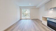 Located at 902 Lytton St in North Vancouver, BC, this thoughtfully designed one-bedroom, one-bathroom unit offers a clean, contemporary aesthetic throughout. Light-toned vinyl plank flooring runs seamlessly across the open-plan living and kitchen area, creating a cohesive and airy feel. The kitchen is well-appointed with light wood cabinetry, a marble-effect tile backsplash, white quartz countertops, and a full suite of stainless steel appliances including a range, dishwasher, and refrigerator. Track lighting overhead enhances the functional workspace. The living area is bright and welcoming, anchored by a large sliding glass door that frames lush, green tree views and allows generous natural light to fill the space. The bedroom is a calm retreat, finished with the same warm flooring and featuring a full-width sliding panel closet for ample storage. The bathroom is finished in crisp white large-format tiles, complete with a soaking tub, toilet, and a light wood vanity with a mirror. Throughout the unit, the neutral white walls and clean lines contribute to a fresh, modern ambiance that is both practical and inviting.