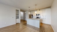 Located at 860 Candlelite Ln. in Columbus, Ohio, this well-appointed single-floor home offers a thoughtfully designed layout with one bedroom and one bathroom across a comfortable footprint. The open-concept kitchen and living area serves as the heart of the home, featuring wood-look flooring, a large center island with granite countertops and an undermount sink, white cabinetry, a subway tile backsplash, and a full suite of stainless steel appliances including a refrigerator, range, microwave, and dishwasher. Pendant and track lighting add a modern touch overhead. The living area is bathed in natural light from multiple windows and provides direct access to a private patio through a glass door. The bedroom is carpeted, generously sized, and includes two windows that bring in ample daylight, along with access to two closets — one of which features wire shelving. The bathroom is finished with a dual-sink granite vanity, white cabinetry, and a tiled walk-in shower. Additional conveniences include a dedicated laundry area, a utility room, and an attached garage with interior access, offering practical storage and parking solutions. The clean, neutral palette throughout gives the space a bright and move-in-ready feel.