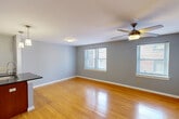 Located at 3830 Park Ave in St. Louis, MO, this 2-bedroom, 1-bathroom unit offers a well-organized single-floor layout designed for comfortable everyday living. The open-concept kitchen and living room serves as the heart of the home, featuring warm hardwood flooring, soft gray walls, and abundant natural light from multiple windows. A ceiling fan adds comfort to the spacious living area. The kitchen is outfitted with rich wood cabinetry, dark granite countertops, a stainless steel double-basin sink with a modern faucet, a built-in microwave, and stylish pendant lighting over the peninsula, which provides additional prep and dining space. Both bedrooms are carpeted and offer a calm, neutral palette, with the primary bedroom featuring a ceiling fan and access to the bathroom via a charming barn-style sliding door. The shared bathroom is well-appointed with marble-look tile flooring and shower surround, a wood vanity with a large mirror, and a tub-shower combination. Additional spaces include a dedicated laundry room, utility room, entrance foyer, and three closets, ensuring ample storage throughout.