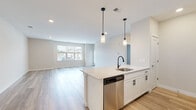 Located at 635 Bay Ave in Toms River, NJ, this single-floor unit presents a clean, modern aesthetic with thoughtfully chosen finishes throughout. The open-concept living and kitchen area forms the heart of the space, where light-toned hardwood-style flooring flows seamlessly underfoot, recessed lighting illuminates the area from above, and large windows invite natural light while offering neighborhood views. A private door provides additional access to the exterior.

The kitchen is well-appointed with white shaker cabinetry featuring matte black hardware, light stone countertops, and a full suite of stainless steel appliances including a gas range, microwave, refrigerator, and dishwasher. A central island with a built-in sink and pendant lighting above serves as both a prep area and a casual gathering point. A textured tile backsplash adds visual interest behind the range.

The bedrooms are carpeted for comfort and feature windows that bring in natural light. The bathroom is finished with white subway tile surrounding the tub and shower, matte black fixtures, tile flooring, and a vanity with matching cabinetry. The overall ambiance throughout the unit is fresh, neutral, and move-in ready.