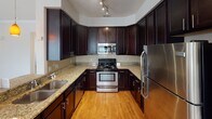 Located at 10930 Dixie Hills Dr in Charlotte, NC, this single-story residence offers a thoughtfully designed layout with a comfortable, functional flow throughout. The open-concept living area is highlighted by plush wall-to-wall carpeting, crown molding, and a ceiling fan, while multiple windows dressed with horizontal blinds allow natural light to fill the space. A pass-through window connects the living area to the kitchen, enhancing the open feel.

The kitchen is well-equipped with rich, dark espresso cabinetry extending to the ceiling, granite countertops, a tile backsplash, stainless steel appliances including a refrigerator, range, and built-in microwave, and wood-look flooring. A peninsula with pendant lighting provides additional counter space.

The bedrooms are generously sized, each featuring carpet flooring, ceiling fans with lighting, natural light from windows, and walk-in or reach-in closets. The primary bathroom includes a dual-sink vanity with dark cabinetry, white countertops, large mirrors, and a tub-shower combination. A secondary full bathroom mirrors the clean, neutral aesthetic with a single-sink vanity and tiled tub surround.