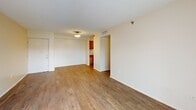 Located at 825 NW 155th Ln in Miami, FL, this 2-bedroom, 2-bathroom unit offers a practical and comfortable single-floor layout. Wood-look flooring runs consistently throughout the space, lending warmth and visual continuity across all rooms.

The living room is a generously proportioned area featuring a textured ceiling, neutral cream-toned walls, and a sliding glass door that opens to a balcony, allowing natural light to fill the space and providing outdoor views of the surrounding neighborhood.

The kitchen is laid out in a galley style, equipped with warm honey-toned wood cabinetry, light countertops, a white electric range, refrigerator, and dishwasher. A range hood and ample upper and lower cabinet storage add to the kitchen's functionality.

Both bedrooms are well-sized with neutral walls, wood-look flooring, and windows that bring in natural light. The primary bedroom includes a louvered closet door, while the second bedroom also features convenient closet access. A central hallway connects the bedrooms to the two bathrooms, each featuring white tile surround tub-shower combinations, vanities, and wood-look flooring, maintaining a clean, uniform aesthetic throughout the unit.
