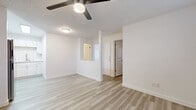 Located at 1038 N 48th St in Phoenix, AZ, this 2-bedroom, 1-bathroom unit offers a thoughtfully organized single-floor layout with a clean, modern aesthetic throughout. Light wood-style vinyl plank flooring runs continuously across the space, complementing the bright white walls and creating a cohesive, airy feel.

The combined kitchen and living area serves as the heart of the unit. The kitchen is equipped with white shaker-style cabinetry, a classic white subway tile backsplash, stainless steel appliances including a refrigerator and range, and a stainless sink — all illuminated by overhead fluorescent lighting. The adjacent living area provides an open, flexible space with a ceiling fan and natural light from blinds-covered windows.

Both bedrooms feature the same light flooring, ceiling fans, and wall-unit HVAC systems. The primary bedroom includes a sliding-door closet, while the second bedroom also accommodates a stacked washer and dryer unit — a practical in-unit laundry convenience. Windows with blinds allow natural light into each room.

The bathroom is finished with a white vanity featuring a stone-look countertop, a full tub/shower combination, and consistent flooring. The overall ambiance of the unit is clean, minimal, and move-in ready.
