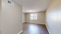 This single-floor residence in Memphis, Tennessee offers a functional and well-organized layout across three bedrooms, one bathroom, and a combined dining and living area. Throughout the home, warm wood-look laminate flooring and neutral beige walls create a consistent, clean aesthetic complemented by white trim and textured ceilings.

The combined living and dining room serves as the central gathering space, offering an open feel with access to the entrance. Each of the three bedrooms features the same wood-look flooring, neutral walls, and windows that allow natural light to fill the rooms. Closet space is generous, with four closets distributed throughout the home.

The bathroom is equipped with a full tub and shower surrounded by large-format tan tiles, a single vanity with a white countertop, and a window that provides natural ventilation. The kitchen connects to the main living areas, while a hallway links the bedrooms and bathroom for a straightforward flow. Two utility rooms provide additional practical storage or functional space. A visible electrical panel is housed within one of the utility areas. The overall ambiance is clean, neutral, and move-in ready, suited for comfortable everyday living.