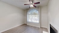 Located at 2343 W Main St in Mesa, Arizona, this one-bedroom, two-bathroom unit offers a well-organized, single-floor layout designed for efficient living. The living room serves as the heart of the space, featuring light wood-style flooring, a clean white fireplace, and a large arched window that floods the room with natural light. A ceiling fan adds comfort, while neutral tones throughout create a bright, airy atmosphere.

The kitchen is thoughtfully designed with white cabinetry, granite-style countertops, and a peninsula that provides additional prep space. Black appliances — including a range, microwave, dishwasher, and refrigerator — offer a bold contrast to the crisp white surroundings. Light wood flooring and a window with vertical blinds complete the functional space.

The bedroom features plush carpeting, a ceiling fan with light fixture, and a sliding glass door that opens to a private outdoor patio, bringing in additional natural light and outdoor views. A dedicated closet adds practical storage.

Both bathrooms are finished in white with light wood-style flooring. The primary bathroom includes a vanity with white cabinetry and a lighted mirror, while the second bathroom features a full tub and shower combination. The unit's consistent use of neutral finishes and natural light gives it a clean, welcoming character throughout.