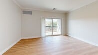 This well-appointed 2-bedroom, 3-bathroom residence at 74 Rockingham Road in Derry, NH offers a thoughtfully designed single-floor layout with a clean, modern aesthetic throughout. Light hardwood flooring flows seamlessly across the open-concept living and kitchen area, complemented by crisp white crown molding and neutral-toned walls that create a bright, welcoming ambiance.

The kitchen is a standout feature, boasting gray shaker-style cabinetry, gleaming white quartz countertops, a full suite of stainless steel appliances including a French door refrigerator, range, microwave, and dishwasher, along with pendant lighting above a peninsula with elegant wainscoting detail. The adjacent living area benefits from natural light and opens to a private balcony through sliding glass doors, offering pleasant outdoor views.

The spacious primary bedroom provides a generous retreat, while the second bedroom features a large window with natural light and matching hardwood floors. Crown molding is carried throughout both bedrooms, reinforcing the refined character of the home. The three bathrooms are finished in neutral tones with tile flooring, including a full bath with a sliding glass shower enclosure. Two hallways and a dedicated closet add to the functional layout of this well-designed residence.