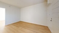 Located at 835 W Rosecrans Ave in Los Angeles, CA, this efficient single-story, 1-bedroom, 2-bathroom unit is thoughtfully designed to maximize every inch of its compact footprint. Light wood laminate flooring runs throughout, lending a clean and cohesive aesthetic across all rooms.

The combined dining and living area is open and airy, benefiting from natural light that filters through horizontal blinds and casts warm, patterned shadows across the floor. A charming shiplap accent wall adds a touch of texture and character to the living space.

The kitchen is open to the main living area and features a peninsula-style breakfast bar with a marble-look countertop, white cabinetry, and a white range — all contributing to the home's crisp, bright palette. A dedicated pantry provides valuable additional storage.

The bedroom is generously proportioned relative to the overall unit and is bathed in natural light from a window. It includes a closet with sliding panel doors, offering practical storage solutions. The textured ceiling carries throughout the space, adding a subtle design layer.

Both bathrooms are finished in clean white tile, with one featuring a full soaking tub and shower combo with chrome fixtures and a window above for natural ventilation. The overall ambiance of the unit is light, minimal, and move-in ready.