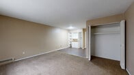 This one-bedroom, one-bathroom unit in Detroit, Michigan offers a straightforward single-floor layout designed for comfortable everyday living. The living area is finished with wall-to-wall carpet and neutral beige walls, creating a warm and inviting atmosphere. A large window dressed with vertical blinds allows natural light to fill the space, while a baseboard heating unit ensures year-round comfort. Built-in white shelving and cabinetry along one wall provide convenient storage and display options, complemented by a bifold-door closet offering additional organization.

The galley-style kitchen features cream-colored upper and lower cabinetry, a wood-toned countertop with an integrated sink, a freestanding electric range, and a full-size refrigerator, all set on durable hardwood-style flooring. The bedroom is a well-proportioned, carpeted room with neutral walls and direct access to the rest of the unit. The full bathroom includes tile flooring, a tiled tub-and-shower combination, a white vanity with sink, and a medicine cabinet mirror, maintaining a clean and functional aesthetic throughout. The unit's cohesive neutral palette and practical layout make it a functional Detroit residence.