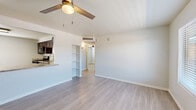Located at 814 E Ninth St in Tucson, Arizona, this single-story, three-bedroom, one-bathroom home offers a clean, modern aesthetic throughout. Light wood-style flooring runs continuously across every room, creating a cohesive and bright interior feel. The open living room and kitchen area serves as the heart of the home, featuring a ceiling fan with light, a built-in shelving nook, and direct sightlines through to the hallway and bedrooms. The kitchen is well-equipped with rich dark wood cabinetry, granite-style countertops, stainless steel gas range, dishwasher, and a refrigerator — offering both style and functionality. Each of the three bedrooms is finished with the same light flooring and ceiling fans, with windows providing natural light and views to the exterior. The primary bedroom includes a ceiling fan and connects to the hallway. The full bathroom is elegantly tiled with white subway tile surrounding a tub/shower combination, accented by a decorative mosaic border, and complemented by a dark wood vanity with granite countertop. A hallway with built-in open shelving adds practical storage. The home presents a clean, move-in ready condition with a consistent, neutral palette throughout.