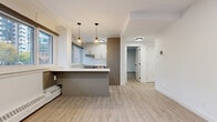 Located at 257 Lisgar St in Ottawa's vibrant Centretown neighbourhood, this thoughtfully updated one-bedroom, one-bathroom unit offers a well-designed layout across a single floor. Light-toned laminate flooring flows throughout, complementing the clean white walls and modern finishes found in every room.

The open-concept living, dining, and kitchen area forms the heart of the unit. A bank of wide windows fills the space with natural light and frames views of the surrounding cityscape and treetops. The kitchen features a central island with a crisp white countertop and taupe cabinetry, a stainless steel range, white upper cabinets, and stylish gold pendant lighting overhead. The living and dining areas offer generous open space ideal for flexible arrangement.

A private balcony is accessible from the main living area, providing an outdoor retreat with neighbourhood views. The spacious primary bedroom includes a sliding-door closet and additional windows that continue the theme of natural light. A second closet is available in the hallway, offering excellent storage.

The bathroom is finished in a clean, contemporary style with white tile surround, a full soaking tub, wood-look flooring, taupe vanity, and matte black fixtures. The entry hallway provides a practical transition into the main living areas, completing this well-appointed urban residence.