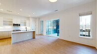 This well-designed single-floor residence offers two bedrooms and two bathrooms within a thoughtfully laid-out floor plan. The open-concept kitchen and living area serves as the heart of the home, featuring light hardwood flooring, recessed lighting, and a seamless flow between spaces. The kitchen is appointed with stainless steel appliances, a built-in microwave, white upper cabinetry with open shelving, warm wood lower cabinets, and a peninsula with a clean white countertop — ideal for dining or meal preparation.

The living area opens directly onto an outdoor balcony through full-width sliding glass doors, filling the space with natural light and providing city skyline views. The primary bedroom, a well-proportioned space, also benefits from sliding glass door balcony access and an additional window, further enhancing natural light. Both bedrooms feature neutral carpet flooring and ceiling fans. Each bedroom is served by a dedicated closet with built-in shelving, hanging rods, drawers, and shoe storage.

The bathrooms are finished in a modern style, featuring wood-toned floating vanities, white countertops, matte black fixtures, glass-enclosed showers, and hardwood-style flooring, creating a clean and cohesive aesthetic throughout the residence.