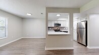Located at 2691 Cypress Bend Dr in Clearwater, Florida, this single-floor residence offers a well-designed layout with contemporary finishes throughout. Wood-look luxury vinyl plank flooring flows seamlessly across all main living areas, complemented by neutral wall tones and textured ceilings that create a clean, cohesive aesthetic.

A welcoming entryway hallway leads into the open living and dining area, where large windows with horizontal blinds allow abundant natural light to fill the space. A black-accented corner fireplace serves as a striking focal point in the living room, adding warmth and character. A glass door provides direct access to the exterior.

The kitchen is equipped with white shaker-style cabinetry, light quartz countertops, a classic subway tile backsplash, and a full suite of stainless steel appliances including a range, over-the-range microwave, dishwasher, and refrigerator. A pass-through window with a breakfast bar connects the kitchen to the main living area, enhancing the open feel.

The bedroom features a ceiling fan, dual windows for natural light, and ample floor space. The bathroom includes a full tub-shower combination with clean white surroundings. A dedicated in-unit laundry closet houses a full-size washer and dryer. This thoughtfully appointed residence offers practical comfort in a desirable Clearwater location.