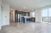 Located at 575 Zor Shrine Pl in Madison, WI, this well-designed 3-bedroom, 2-bathroom residence offers a clean, contemporary aesthetic throughout its single-floor layout. Light wood-style flooring flows through the main living areas, complementing the neutral palette of white and warm beige tones found throughout.

The kitchen is a standout feature, showcasing rich dark wood cabinetry, stainless steel appliances including a refrigerator, range, microwave, and dishwasher, and a central island with open shelving. A window above the sink brings in natural light, enhancing the functional workspace.

The living room is bright and airy, featuring sliding glass doors that open to a private balcony with outdoor views, alongside an additional window that fills the space with natural light.

The generously sized primary bedroom includes its own walk-in closet outfitted with built-in shelving, hanging rods, and carpeted flooring for added comfort. The two additional bedrooms are carpeted, each with large windows offering natural light and exterior views, with one featuring a ceiling fan.

Both bathrooms are finished in a modern style, featuring dark-hardware fixtures, undermount sinks, wood-tone vanity cabinetry, and light hardwood-style flooring. The primary bathroom includes a walk-in shower, while the secondary bathroom offers a clean, efficient layout.