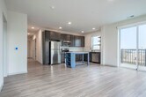 Located at 575 Zor Shrine Pl in Madison, WI, this well-designed 3-bedroom, 2-bathroom residence offers a clean, contemporary aesthetic throughout its single-floor layout. Light wood-style flooring flows through the main living areas, complementing the neutral palette of white and warm beige tones found throughout.

The kitchen is a standout feature, showcasing rich dark wood cabinetry, stainless steel appliances including a refrigerator, range, microwave, and dishwasher, and a central island with open shelving. A window above the sink brings in natural light, enhancing the functional workspace.

The living room is bright and airy, featuring sliding glass doors that open to a private balcony with outdoor views, alongside an additional window that fills the space with natural light.

The generously sized primary bedroom includes its own walk-in closet outfitted with built-in shelving, hanging rods, and carpeted flooring for added comfort. The two additional bedrooms are carpeted, each with large windows offering natural light and exterior views, with one featuring a ceiling fan.

Both bathrooms are finished in a modern style, featuring dark-hardware fixtures, undermount sinks, wood-tone vanity cabinetry, and light hardwood-style flooring. The primary bathroom includes a walk-in shower, while the secondary bathroom offers a clean, efficient layout.