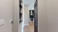 This well-designed 710 square foot apartment maximizes space and light, offering a comfortable living environment. The heart of the home is a bright, open-concept living and kitchen area, showcased in the image. A standout feature is the set of three French doors, framed in dark wood, which flood the space with natural light. These doors are topped with transom windows, enhancing the room's airy feel.

The flooring throughout is a warm, wood-look laminate, providing durability and a modern aesthetic. Clean, off-white walls contribute to the sense of spaciousness and offer a neutral backdrop for personalization. Recessed lighting in the ceiling provides even illumination.

The 150 square foot primary bedroom offers ample space for rest and relaxation. While not visible in the image, the apartment includes a full bathroom and a closet for storage. The efficient layout incorporates a hallway, likely connecting these spaces.

This single-floor dwelling is ideal for those seeking a low-maintenance lifestyle without sacrificing style or comfort. The combination of contemporary finishes and thoughtful design creates an inviting atmosphere in this compact yet functional urban living space.