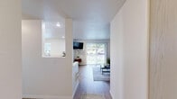 Located at 12623 E Broadway Ave in Spokane Valley, WA, this one-bedroom, one-bathroom residence offers a thoughtfully designed single-floor layout with a functional and comfortable living environment. The open-concept living room features warm hardwood-style flooring, large windows, and a sliding glass door that floods the space with natural light and provides access to a private outdoor patio with views of the surrounding greenery. The living area offers a welcoming ambiance with neutral tones and ample room for relaxing and entertaining. The kitchen is well-equipped with light wood cabinetry, generous counter space, a full suite of white appliances including a refrigerator and electric range, and a double basin sink positioned beneath a window. The layout promotes easy movement between the kitchen and living areas. The spacious bedroom features plush wall-to-wall carpeting and a clean, bright atmosphere with plenty of room for a full furniture arrangement. A hallway connects the main spaces and leads to the full bathroom, which includes a vanity with a built-in sink, wood-toned cabinetry, hardwood-style flooring, and a full soaking tub with a tiled shower surround. The overall design is clean, neutral, and move-in ready.