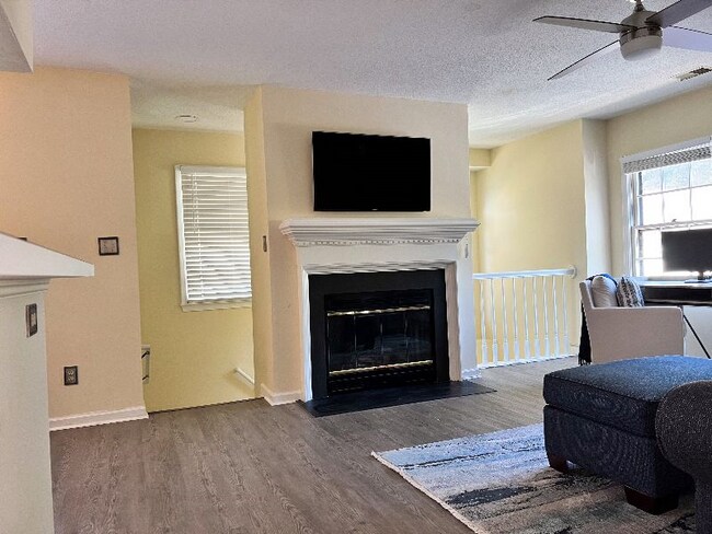 Living room view and stairwell entrance view from hallway. - 704 Rapidan River Ct