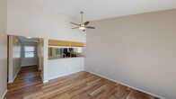 Located at 37850 Spring Ln in Farmington Hills, Michigan, this single-floor home offers a well-designed layout with a variety of functional and aesthetic features throughout. The main living area is immediately impressive with its soaring vaulted ceilings and a ceiling fan that enhances the sense of openness. Durable hardwood-style flooring flows through the main living spaces, complementing the neutral, warm-toned walls. Vertical blinds along the sliding door allow for flexible natural light control. A dedicated sitting or family room features a corner fireplace with a sleek dark tile surround, creating a cozy focal point anchored by a bright window. The kitchen is equipped with white cabinetry, granite-style countertops, stainless steel appliances including an electric range and over-the-range microwave, and a pass-through window that connects it to the main living area. The bedroom features plush carpeting and a generously sized window that brings in natural light, offering a comfortable and quiet retreat. The bathroom is finished with tile-surround tub and shower combination, a full vanity with a large mirror, and wood-style flooring. Overall, the home presents a clean, functional, and inviting atmosphere well-suited for comfortable living.