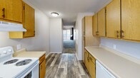 Located at 2719 S Emporia St in Wichita, KS, this apartment offers a practical and comfortable single-floor layout with three bedrooms, two bathrooms, and a dedicated kitchen. The kitchen is efficiently designed with ample warm-toned wood cabinetry, white countertops, a double-basin sink, and white appliances including a range and dishwasher. Wood-look plank flooring runs throughout the kitchen and main living areas, providing durability and visual continuity. The open entryway leads into a carpeted living area with neutral tones, creating a clean and welcoming atmosphere. Each of the three bedrooms features plush carpet, natural light from windows with blinds, and textured ceilings. The spacious primary bedroom includes a built-in closet with sliding doors, offering ample storage. The two bathrooms are each equipped with a tub-shower combination and overhead cabinetry, maintaining a consistent, clean aesthetic throughout. A dedicated closet provides additional storage. The unit's neutral color palette and straightforward layout make it a versatile and move-in-ready space suited for a variety of living arrangements.
