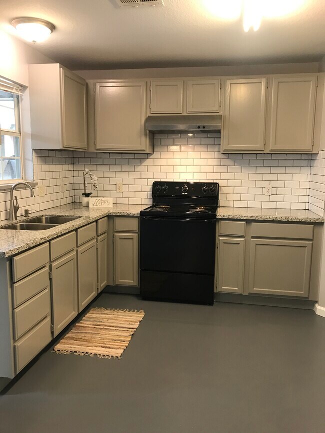 Cocina reformada con encimeras nuevas y un elegante revestimiento de pared. - 222 S Kansas Ave