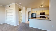 Located at 2155 E Liberty Ln in Phoenix, AZ, this single-floor residence offers a well-organized layout designed for comfortable everyday living. The open-concept kitchen is equipped with light wood cabinetry, black appliances including a refrigerator, electric range, and over-the-range microwave, along with a peninsula countertop that provides additional prep space and a natural connection to the living area. A dedicated pantry closet offers generous storage. The living room features plush carpeting, crown molding, a ceiling fan, and a large window fitted with vertical blinds that allow natural light to filter in. A sliding glass door leads to a private patio, extending the living space outdoors. The bedrooms are carpeted and generously sized, each with ceiling fans and six-panel doors. The bathroom includes a tiled tub-shower combination, a toilet, and a vanity topped with a granite-style countertop and a wide mirror. A dedicated in-unit laundry room accommodates a full-size washer and dryer side by side on tile flooring. Throughout the home, neutral warm tones, tile flooring in wet areas, and consistent trim details create a cohesive and functional living environment suited to the Phoenix climate.