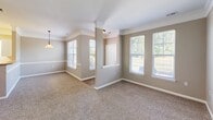 This one-bedroom, one-bathroom unit in Fort Wayne, Indiana offers a well-organized, single-floor layout designed for comfortable everyday living. The open-concept great room seamlessly combines the living, dining, and kitchen areas, creating a bright and cohesive space. Large windows fitted with blinds allow generous natural light to fill the living and dining areas, while plush carpet underfoot adds warmth throughout. A decorative column detail subtly defines the transition between the living and dining spaces, adding a touch of architectural character.

The kitchen is efficiently laid out in a galley style, featuring white cabinetry with ample upper and lower storage, granite-look countertops, wood-look flooring, and white appliances including a range and refrigerator. A peninsula counter with a raised breakfast bar opens toward the living area, enhancing the sense of connectivity throughout the main living space.

The bedroom is generously proportioned, offering plush carpeting, a ceiling fan, and a large window with views of the outdoors. Five closets throughout the unit provide exceptional storage capacity, a standout practical feature.

The bathroom includes a single vanity with granite-look countertops, white cabinetry, dual mirrors, and wood-look flooring, offering a clean and functional design. The neutral warm-beige palette carried throughout the unit creates a cohesive and inviting atmosphere.