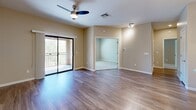 Located at 9750 N Oracle Rd in Tucson, Arizona, this well-designed 2-bedroom, 2-bathroom residence offers a thoughtful single-level layout with modern finishes throughout. The open-concept kitchen and living area serves as the heart of the home, showcasing rich dark wood cabinetry, a tiled mosaic backsplash, stainless steel appliances, and a large center island with a white quartz countertop and undermount sink — illuminated by elegant pendant lighting. Wood-style flooring runs seamlessly through the main living area, which features a ceiling fan and sliding glass doors opening to a private balcony with lush outdoor views. The two bedrooms are carpeted for comfort, each with ceiling fans and ample closet space featuring sliding panel doors. The primary bedroom is generously sized with a window overlooking greenery. The two bathrooms are finished in neutral tones with wood-look tile flooring — one features a walk-in shower with sliding glass doors, while the other offers a shower/tub combination. Warm beige walls and recessed lighting throughout contribute to a clean, contemporary ambiance well-suited to the Tucson lifestyle.