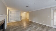 Located at 9200 Roberts Dr. in Sandy Springs, GA, this single-story residence offers a well-designed layout with a cohesive, neutral color palette throughout. The open living and dining area is highlighted by rich wood-look flooring, crown molding, and a ceiling fan with light fixture. A chandelier illuminates the dining space, which connects seamlessly to the living area through an open-concept flow. A built-in shelving unit adds functional character to the living room, while a private exterior door and large windows invite abundant natural light and views of surrounding greenery.

The galley-style kitchen is equipped with dark espresso cabinetry, light stone-look countertops, a tile backsplash, and stainless steel appliances including a range and dishwasher. A pass-through counter opening connects the kitchen to the main living area. Bedrooms feature plush carpeting, ceiling fans, and windows overlooking the wooded surroundings. The bathroom includes a full soaking tub with white tile surround, adding a clean, classic finish. Throughout the space, consistent trim work, textured ceilings, and warm tones create a comfortable and well-maintained living environment.