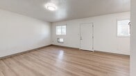 Located at 701 E Pennington St in West Burlington, Iowa, this 2-bedroom, 1-bathroom unit offers a clean, functional layout across a single floor. Light wood-style flooring runs throughout the entire space, providing a cohesive and bright aesthetic complemented by crisp white walls and textured ceilings.

The combined kitchen and living area forms the heart of the unit. The kitchen features white shaker-style cabinetry, light quartz countertops, stainless steel appliances including a refrigerator and electric range, and a window that brings in natural light. The adjacent living area is open and spacious, with multiple windows, a front entry door, and a wall-mounted heating unit.

The primary bedroom offers comfortable accommodations with two closets, a wall shelf, and a ceiling vent, providing ample storage. The second bedroom is bright and airy, with a window fitted with blinds and easy access to the hallway. A connecting hallway links the bedrooms to the full bathroom, which includes a vanity with storage, a toilet, and a shower-tub combination with built-in shelving.

The unit's consistent use of light tones, wood-style flooring, and white finishes throughout creates a clean, move-in-ready atmosphere well-suited for comfortable everyday living.