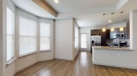 Located at 1639 Cable Ranch Rd in San Antonio, Texas, this two-story residence offers a thoughtfully designed layout spread across two levels. The main living area is open and airy, anchored by warm hardwood-style flooring and a striking bay window configuration that floods the space with natural light. A neutral color palette enhances the bright, welcoming ambiance throughout.

The kitchen is a standout feature, boasting rich dark cabinetry, granite countertops with a complementary tile backsplash, and a full suite of stainless steel appliances including a side-by-side refrigerator with ice maker, a gas range with microwave above, and a large peninsula ideal for casual dining or meal prep. Pendant lighting adds a refined touch overhead.

The bedrooms are carpeted for comfort, offering a soft contrast to the hard flooring in the main living areas. The primary bathroom is well-appointed with a dual-sink vanity topped with granite, dark cabinetry, and a large mirror. A separate tiled tub-shower combo provides a clean, modern finish. A generously sized walk-in closet with built-in wire shelving provides ample storage. The lower level includes a large unfinished garage space, offering significant utility and storage potential.