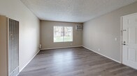 Located at 5351 47th Ave in Sacramento, CA, this 2-bedroom, 1-bathroom unit offers a practical and well-organized single-floor layout. Throughout the space, light-toned wood-style flooring runs continuously, complemented by neutral beige walls and textured ceilings that lend a consistent, cohesive look to every room.

The combined kitchen and living area forms the heart of the unit. The kitchen features white cabinetry, light countertops, a sink, dishwasher, and refrigerator, providing ample functionality for everyday use. The adjacent living area is open and receives natural light through a large window with views of the surrounding greenery.

Both bedrooms are well-proportioned, with the primary bedroom offering generous space and a dedicated closet with built-in shelving. Each bedroom includes windows fitted with blinds, allowing for natural light and outdoor views of the landscaped community grounds. A wall-mounted air conditioning unit is present in the main living space for climate control.

The bathroom is clean and efficient, featuring a full tub-shower combination with a curtain rod, toilet, and wood-style flooring that matches the rest of the unit. A closet provides additional storage within the layout. The overall ambiance is bright, neutral, and move-in ready.