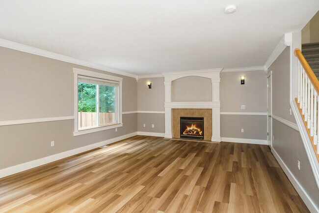 Sala de estar con vistas al área verde y chimenea a gas. - 7613 56th Pl NE