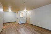 Located at 3111 132nd St SE in Everett, Washington, this one-bedroom, one-bathroom unit offers a well-organized single-floor layout designed for comfortable everyday living. The open living area greets you upon entry, featuring light wood-style plank flooring, neutral white walls, and flush ceiling lighting that creates a clean, bright atmosphere. A pass-through window connects the living space to the galley-style kitchen, which is equipped with light wood cabinetry, white appliances including a refrigerator, electric range, microwave, and dishwasher, all set over matching wood-style flooring. The living area also benefits from a sliding glass door that opens to a private balcony, inviting natural light and outdoor views of surrounding greenery. The bedroom is a comfortable, well-proportioned room with plush gray carpeting, a window overlooking lush trees, and a baseboard heater. It connects conveniently to the bathroom, which features a full soaking tub and shower combination with chrome fixtures, a herringbone-patterned tile floor, and light-toned surround walls. The unit also includes a dedicated vanity area with warm wood-toned cabinetry. Throughout the space, a consistent neutral color palette and practical finishes create a cohesive, move-in-ready environment.