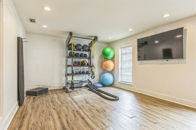 Disfrute de entrenamientos variados con balones medicinales y entretenimiento en televisores montados en la pared en nuestra sala de fitness bien equipada, operada profesionalmente por Highlands Vista Group. - Ashford Place
