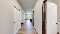 Located at Olympic Pl NE in Arlington, WA, this single-floor studio unit offers a thoughtfully designed open layout that maximizes functionality and flow. Light hardwood-style flooring runs throughout the space, complemented by crisp white walls, dark wood trim, and recessed lighting that keeps the interior bright and welcoming.

The kitchen is a standout feature, showcasing rich dark wood cabinetry, light quartz-style countertops, a tile backsplash, and a full suite of stainless steel appliances including a refrigerator, range, microwave, and dishwasher. A center island provides additional prep space and casual dining potential. The open-concept design connects the kitchen seamlessly to the main living area, which benefits from a large window that brings in natural light and views of the surrounding greenery.

A hallway leads to the full bathroom, which features a dark wood vanity with a dual-sink countertop, a tile accent backsplash, a large mirror, and a soaking tub with a shower. The bathroom maintains the same warm, cohesive finishes found throughout the unit. An additional room off the hallway offers flexible use as a sleeping or living area, also featuring a window with pleasant outdoor views. The overall design is clean, modern, and move-in ready.