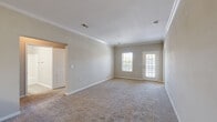 Located at 5300 Patron Pl in North Charleston, SC, this single-story, 3-bedroom, 2-bathroom home offers a well-designed layout with a comfortable and functional flow throughout. The open-concept living room greets you with soft carpeting, crown molding, and natural light streaming through a front-facing window and glass-paneled entry door, creating a bright and welcoming atmosphere. Crown molding is carried consistently throughout the main living areas, adding a refined architectural touch.

The kitchen is a standout feature, designed in a galley style with rich dark wood cabinetry, dark granite-style countertops, a double sink, and black appliances including a range, microwave, and dishwasher. A breakfast bar peninsula visually connects the kitchen to the living area. Light tile flooring runs through the kitchen and wet areas, providing a clean contrast to the carpeted rooms.

The spacious primary bedroom comfortably accommodates large furnishings and includes a ceiling fan. The two additional bedrooms feature plush carpeting, crown molding, and windows with natural views. Three closets provide ample storage throughout. Both bathrooms are finished with tile flooring, dark wood vanities with granite-style counters, and one includes a full tub-shower combo.