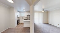 Located at 8035 Ohio Dr in Plano, TX, this well-designed one-bedroom, one-bathroom residence offers a smartly functional layout across a single floor. The open-concept kitchen is a standout feature, boasting crisp white shaker cabinetry, light wood-look flooring, a tiled backsplash, and a full suite of stainless steel appliances including a refrigerator, dishwasher, and range. A peninsula counter with a clean white surface provides extra prep space and connects the kitchen to the living area through a charming arched passageway. The living area is carpeted and benefits from natural light via vertical blinds over a sliding door, and is complemented by a ceiling fan overhead. The bedroom is a comfortable, carpet-floored retreat featuring a large window with horizontal blinds that frames outdoor views. The bathroom includes a full tub-shower combination with brushed nickel fixtures, white cabinetry, and direct access to a walk-in closet with wire shelving. An in-unit laundry area with a full-size washer and dryer tucked behind louvered doors adds everyday convenience. Neutral tones and clean finishes throughout lend the space a bright, cohesive ambiance.