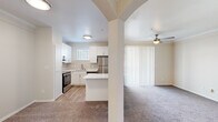 Located at 8035 Ohio Dr in Plano, TX, this well-designed one-bedroom, one-bathroom residence offers a smartly functional layout across a single floor. The open-concept kitchen is a standout feature, boasting crisp white shaker cabinetry, light wood-look flooring, a tiled backsplash, and a full suite of stainless steel appliances including a refrigerator, dishwasher, and range. A peninsula counter with a clean white surface provides extra prep space and connects the kitchen to the living area through a charming arched passageway. The living area is carpeted and benefits from natural light via vertical blinds over a sliding door, and is complemented by a ceiling fan overhead. The bedroom is a comfortable, carpet-floored retreat featuring a large window with horizontal blinds that frames outdoor views. The bathroom includes a full tub-shower combination with brushed nickel fixtures, white cabinetry, and direct access to a walk-in closet with wire shelving. An in-unit laundry area with a full-size washer and dryer tucked behind louvered doors adds everyday convenience. Neutral tones and clean finishes throughout lend the space a bright, cohesive ambiance.