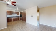 This single-story home at 3636 Jackson St in Riverside, California offers a straightforward, functional layout with consistent light wood-style flooring running throughout the main living areas and bedrooms. The living room serves as the entry point to the home, featuring a ceiling fan, a wall-mounted mini-split air conditioning unit, and a paneled front door flanked by sidelight windows that allow natural light to filter in. Neutral beige walls provide a clean, versatile backdrop throughout the space.

The kitchen is well-equipped with an abundance of warm wood-toned cabinetry extending from countertop height to the ceiling, offering substantial storage. Dark granite-style countertops complement the cabinetry, and black appliances—including a wall oven, cooktop, and refrigerator—complete the cooking area. A range hood is installed above the cooktop for ventilation.

The bedrooms feature the same light wood-style flooring and ceiling fans. One bedroom includes a wide mirrored sliding-door closet that enhances the sense of space and reflects natural light from a window fitted with blinds. An additional room provides flexible use as a bedroom or secondary living space. The bathroom includes a full soaking tub with a surrounding surround panel enclosure.