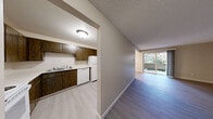 Located at 402 N G St in Tacoma, WA, this two-bedroom, one-bathroom unit offers a well-organized single-floor layout that makes efficient use of its space. Light-toned luxury vinyl plank flooring runs throughout the main living areas, while plush carpet adds warmth to both bedrooms. The open living room features a ceiling fan, a baseboard heating unit, and connects seamlessly to a private balcony through sliding glass doors — ideal for bringing in natural light. Adjacent to the living area, the combined dining and kitchen space is equipped with dark wood cabinetry, white appliances including a refrigerator, electric range, and dishwasher, along with a double sink and light countertops. Both bedrooms are carpeted and include sliding-door closets for ample storage, with baseboard heaters and windows that allow natural light to fill each room. The full bathroom features a tub/shower combo, toilet, and a vanity with dark wood cabinetry and a single sink. Textured ceilings are present throughout the unit, lending a classic residential aesthetic. A connecting hallway ties all rooms together efficiently. The unit also includes two closets, providing practical additional storage throughout.