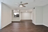 Located in Kennesaw, GA, this single-floor residence offers a thoughtfully designed layout with a blend of comfort and modern updates throughout. The open living area serves as the heart of the home, featuring rich hardwood-style flooring, a ceiling fan, and natural light streaming through windows that overlook lush greenery outside. A pass-through connects the living space to the kitchen, which is outfitted with white shaker-style cabinetry, dark countertops, a subway tile backsplash, stainless steel appliances including a refrigerator, range, microwave, and dishwasher, and built-in open shelving for additional storage. The bedrooms are carpeted and well-sized, each featuring ceiling fans, windows with outdoor views, and ample closet space. Two bathrooms complete the layout — one featuring a white vanity with dark countertop, a large framed mirror, hardwood-style flooring, and a tub-shower combination with a safety grab bar; the other offering a single-sink vanity with a wide mirror, dark countertop, and matching hardwood-style flooring. Neutral gray wall tones carry throughout, lending the space a cohesive and contemporary feel. A laundry area is also visible, adding to the home's practical functionality.