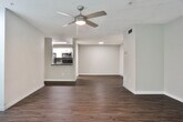 Located in Kennesaw, GA, this single-floor residence offers a thoughtfully designed layout with a blend of comfort and modern updates throughout. The open living area serves as the heart of the home, featuring rich hardwood-style flooring, a ceiling fan, and natural light streaming through windows that overlook lush greenery outside. A pass-through connects the living space to the kitchen, which is outfitted with white shaker-style cabinetry, dark countertops, a subway tile backsplash, stainless steel appliances including a refrigerator, range, microwave, and dishwasher, and built-in open shelving for additional storage. The bedrooms are carpeted and well-sized, each featuring ceiling fans, windows with outdoor views, and ample closet space. Two bathrooms complete the layout — one featuring a white vanity with dark countertop, a large framed mirror, hardwood-style flooring, and a tub-shower combination with a safety grab bar; the other offering a single-sink vanity with a wide mirror, dark countertop, and matching hardwood-style flooring. Neutral gray wall tones carry throughout, lending the space a cohesive and contemporary feel. A laundry area is also visible, adding to the home's practical functionality.