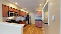 Located at 1 Marlbrook Lane in Lansdale, Pennsylvania, this single-floor residence offers a thoughtfully designed living space with functional and stylish finishes throughout. The kitchen is a standout feature, showcasing warm medium-toned wood cabinetry paired with dark stone countertops that provide a striking contrast. Stainless steel appliances — including a refrigerator, range, microwave, and dishwasher — lend a modern, polished look to the space. A classic white tile backsplash adds a clean, bright accent behind the cooking area, while recessed lighting ensures the kitchen is well-lit throughout. The layout is highly functional, with ample upper and lower cabinet storage and generous counter space that extends to a peninsula-style breakfast bar, perfect for casual dining or food preparation. Durable hardwood-style flooring runs throughout, adding warmth and cohesion to the space. The open design allows for an easy flow between the kitchen and adjacent living areas, creating a welcoming and practical environment. Neutral wall tones complement the overall palette, making the space feel bright and move-in ready. This residence combines comfortable everyday living with quality finishes in a convenient Lansdale location.