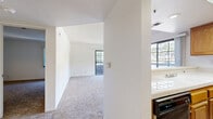 Located at 7282 Franklin Ave in the heart of Los Angeles, this one-bedroom, one-bathroom apartment offers a well-organized layout across a single floor. The living room serves as the centerpiece of the unit, featuring a classic wood-trimmed fireplace, soft carpeting, a ceiling fan, and large sliding glass doors that open to a private outdoor space, flooding the room with natural light and views of lush greenery. An adjacent window further enhances the bright, airy ambiance.

The kitchen is thoughtfully designed with warm honey-toned wood cabinetry, tile countertops, light wood-style vinyl flooring, and a full suite of black appliances including a refrigerator, gas range, dishwasher, and microwave. A breakfast bar peninsula connects the kitchen to the living area, creating an open and functional flow.

The bedroom is a comfortable, carpeted retreat with a large window that brings in natural light. It is complemented by a dedicated walk-in closet outfitted with built-in shelving and hanging rods, providing ample storage. The bathroom features a wide vanity with a generous mirror, light stone-finish countertop, wood-style vinyl flooring, and a tiled shower-tub combination with sliding glass doors.