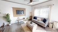 This single-floor, 1-bedroom, 1-bathroom residence offers a thoughtfully designed layout with a coastal-inspired aesthetic that flows seamlessly from room to room. The living area features durable wood-look flooring, a ceiling fan, and a custom wood accent wall with a mounted flat-screen TV, creating a warm and inviting focal point. Natural light pours in through blinds-fitted windows, brightening the crisp white walls and neutral décor.

Adjacent to the living area, a cozy dining nook features a rich, deep-toned accent wall that adds a bold contrast to the surrounding space, complemented by a round wood dining table and window with natural light.

The kitchen is equipped with dark cabinetry, granite countertops, stainless steel appliances including an electric range and built-in microwave, and ample storage space, including a pantry closet. Wood-look flooring continues throughout this area, maintaining a cohesive feel.

The bedroom is a serene retreat, highlighted by a striking blue accent wall, plush carpeting, a ceiling fan, a natural light-filled window, and direct access to a walk-in closet. The bathroom includes a full tub-shower combination with clean white tile surround. This unit balances functional living with stylish, detail-oriented design.