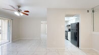 This single-floor, 1-bedroom, 1-bathroom unit offers an efficient and thoughtfully organized layout. Polished marble-look porcelain tile flows seamlessly throughout every room, lending a clean, cohesive aesthetic to the entire space. The open-plan living, dining, and kitchen areas are connected and brightened by natural light, with ceiling fans providing additional comfort in the main living area. The kitchen is positioned off the main living space and features white cabinetry, black appliances including a refrigerator and range, and overhead ventilation, making it a practical and accessible cooking area. A sliding glass door in the living area opens to the outside, filling the room with natural light and providing convenient outdoor access. The bedroom is a comfortable, well-proportioned room with its own ceiling fan, a window with blinds, and direct access to a walk-in closet equipped with built-in shelving. The bathroom includes a full tub-shower combo with white tile surround, a toilet, and a vanity with a granite-style countertop. The walk-in closet continues the marble-look tile and offers ample shelving for organized storage. The overall ambiance is bright, neutral, and move-in ready.